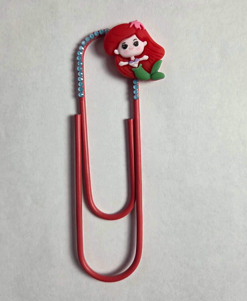 Red paper clip with a mermaid charm